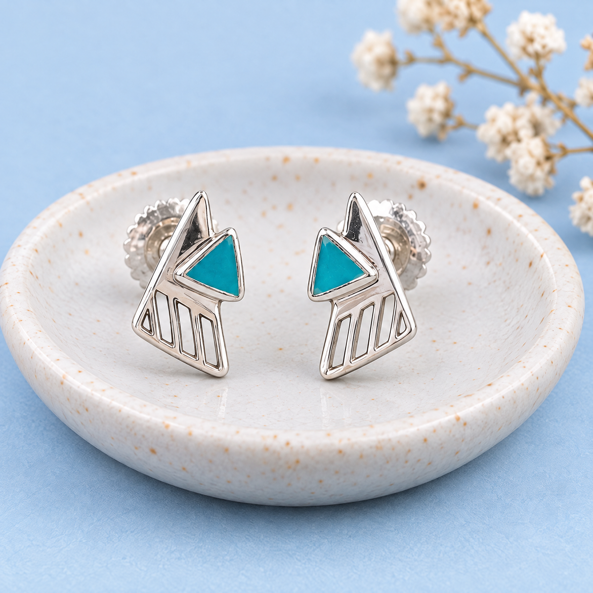 Teal Triangle Enamel Stud Earrings in 925 sterling silver, on a ceramic dish