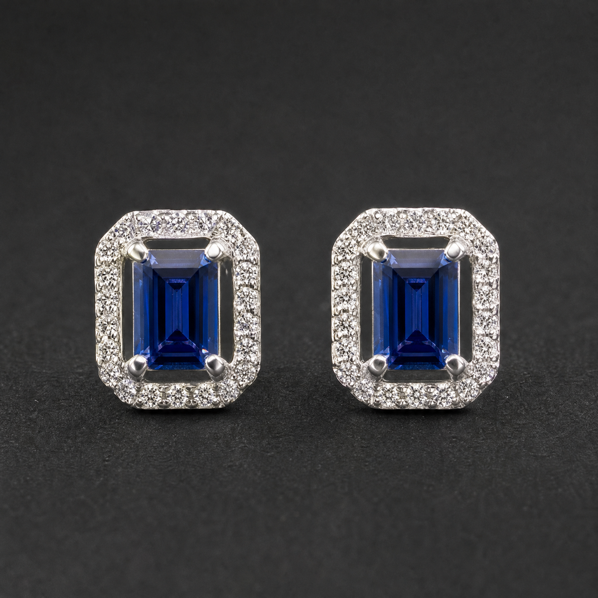 Blue Step Cut Halo Stud Earrings in 925 sterling silver, on a dark background