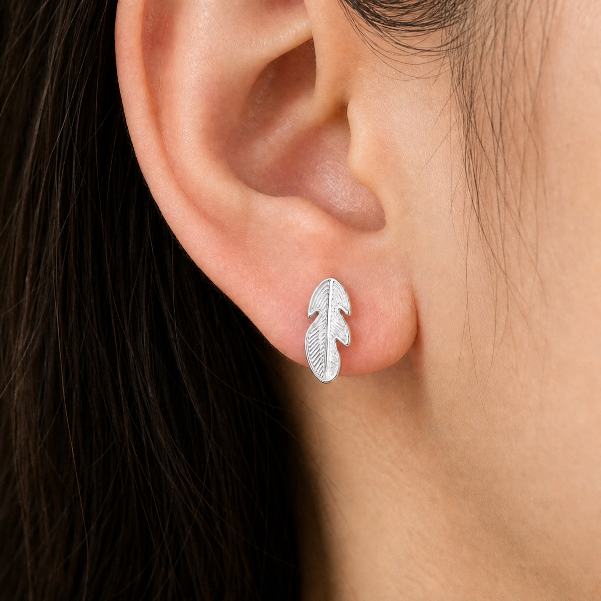 Engraved Feather Stud Earrings in 925 sterling silver, worn on the ear