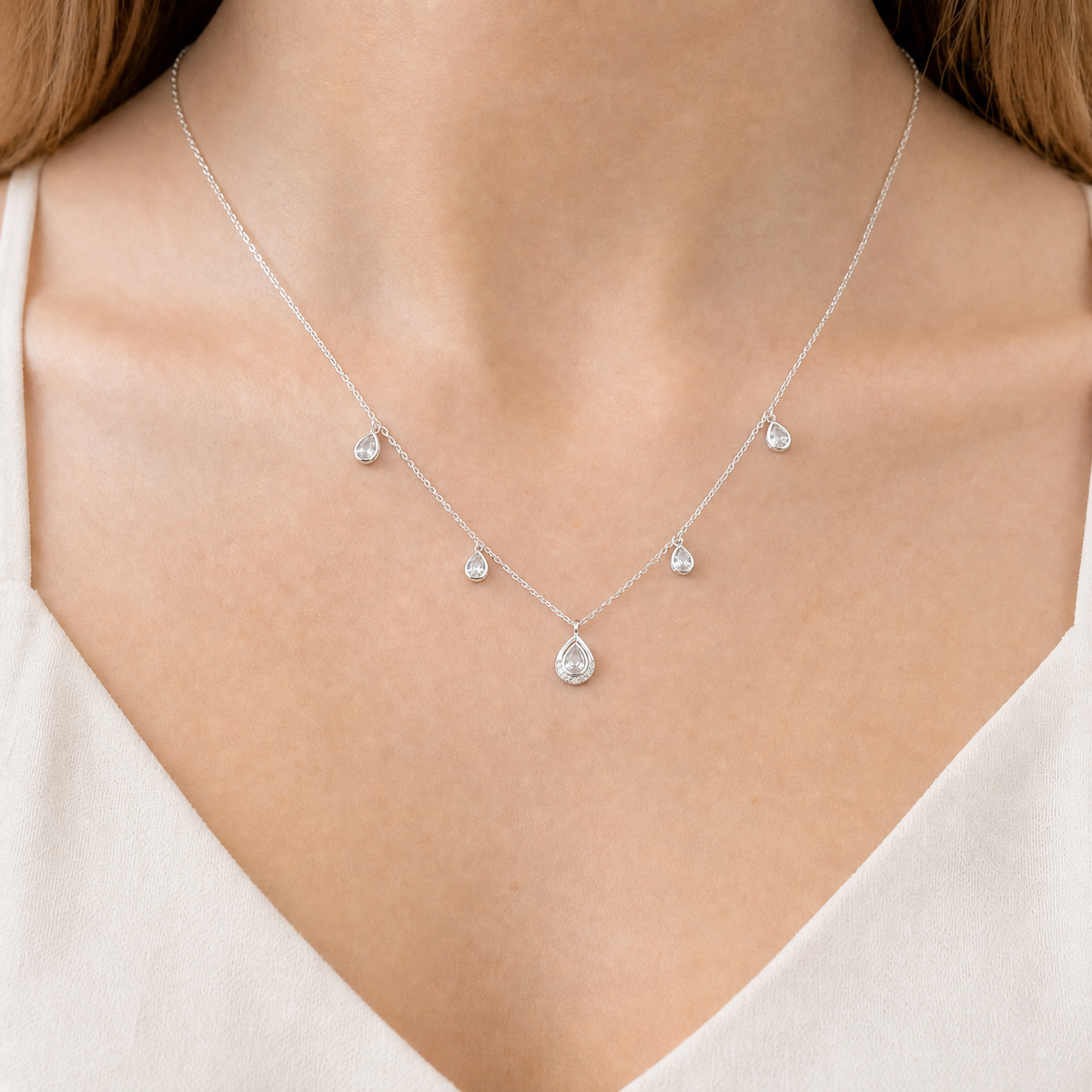 Pear Halo Station Necklace in 925 sterling silver, worn at the neckline