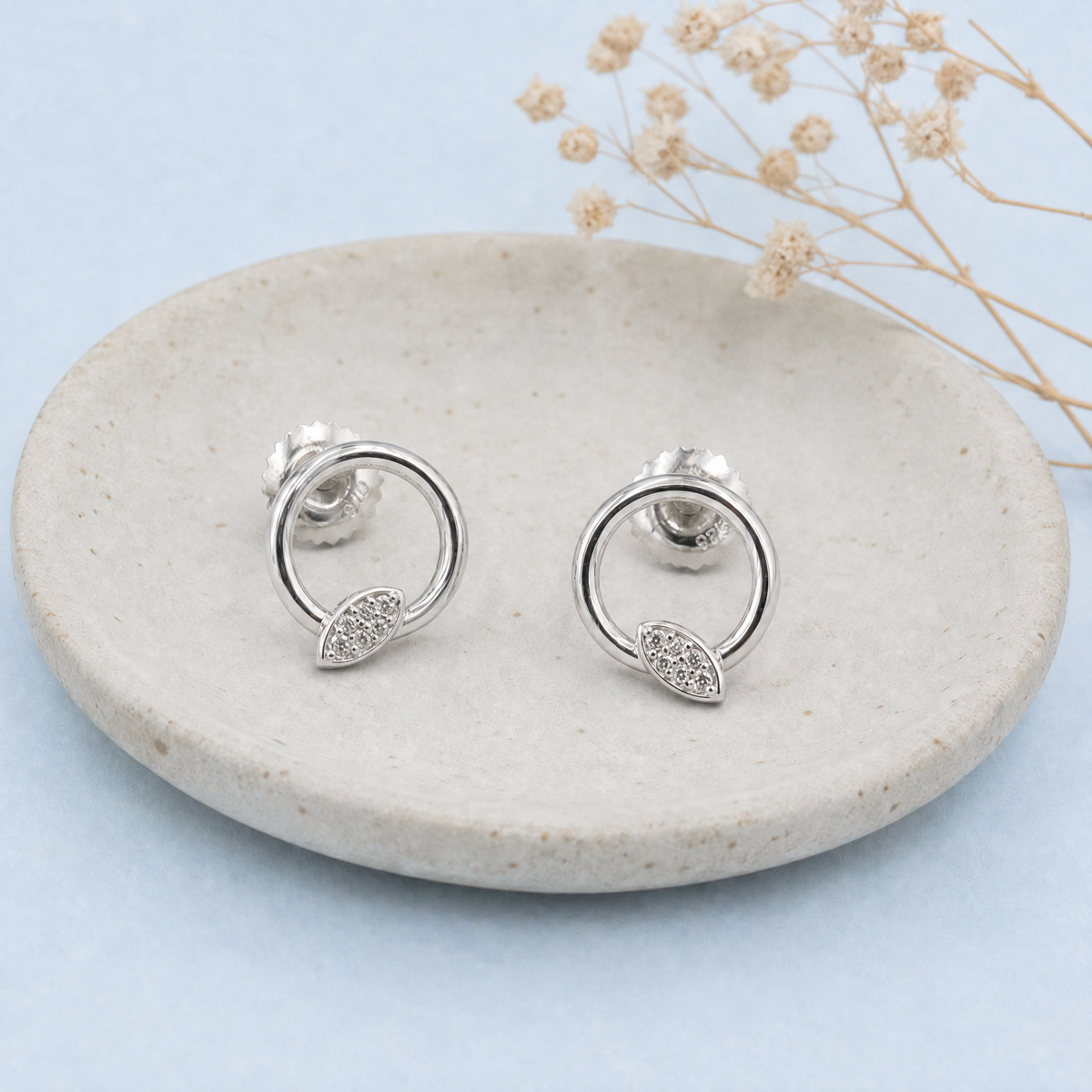 Leaf Sparkle Circle Stud Earrings in 925 sterling silver, on a ceramic dish