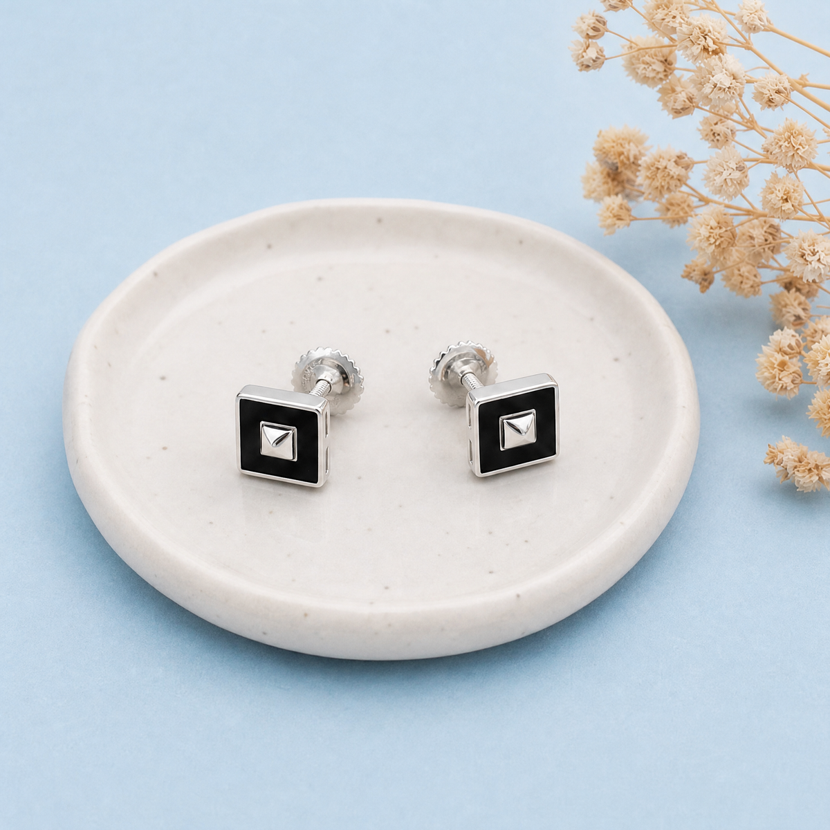 Art Deco Black Square Stud Earrings in 925 sterling silver, on a ceramic dish