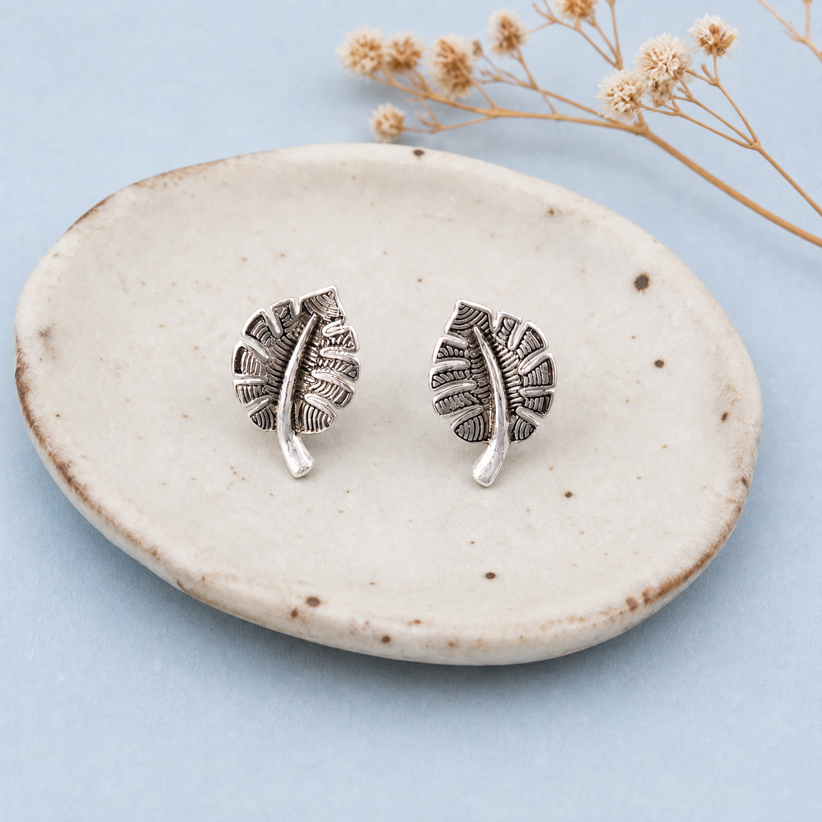Textured Leaf Stud Earrings in 925 sterling silver, on a ceramic dish