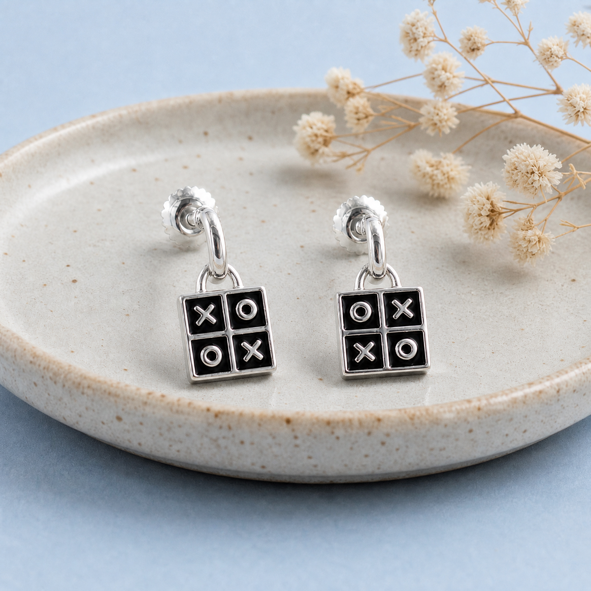 Tic Tac Toe Enamel Drop Earrings in 925 sterling silver, on a ceramic dish