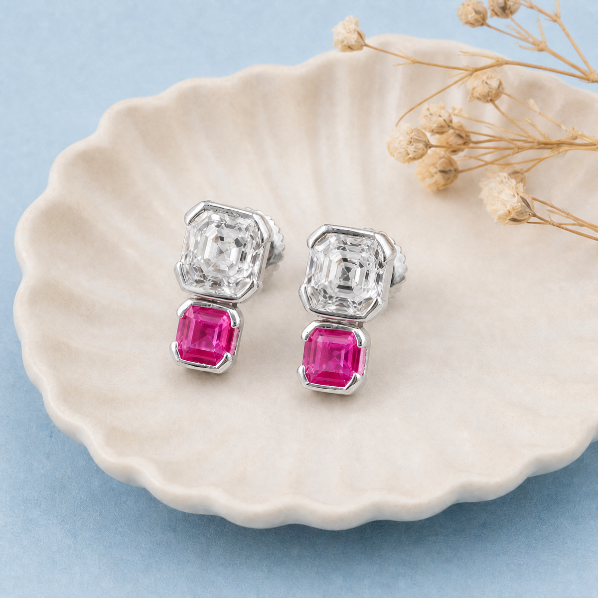 Stacked Clear and Pink Stud Earrings in 925 sterling silver, on a ceramic dish