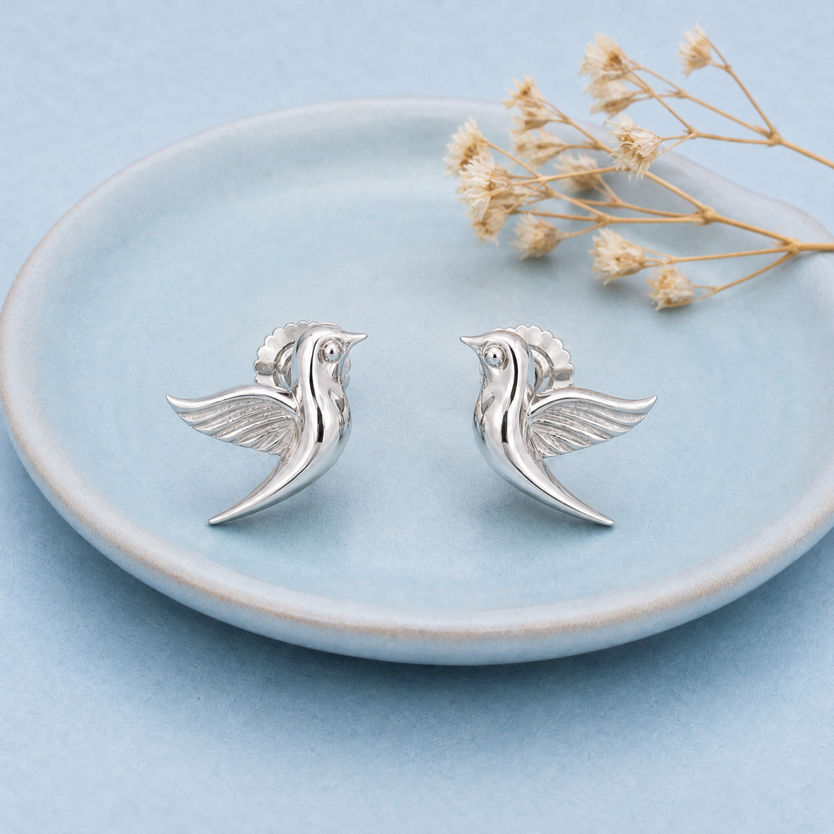 Songbird Stud Earrings in 925 sterling silver, on a ceramic dish