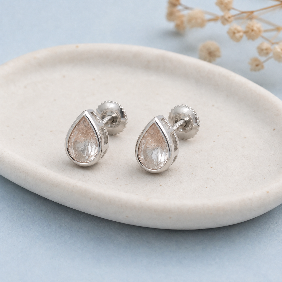 Blush Pear Bezel Stud Earrings in 925 sterling silver, on a ceramic dish