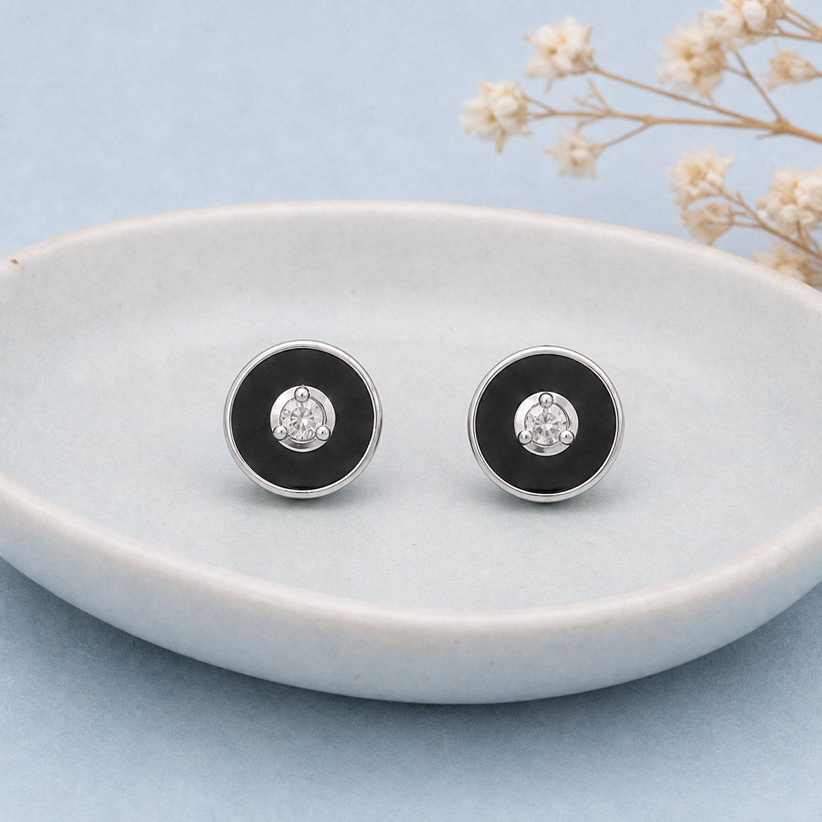 Black Enamel Disc Stud Earrings in 925 sterling silver, on a ceramic dish