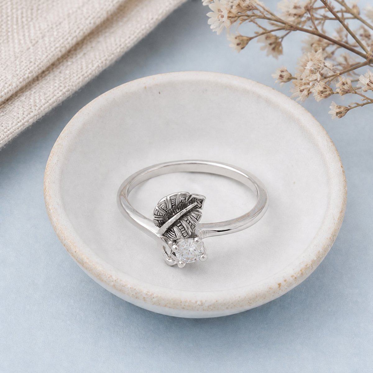 Dark Leaf Clear Stone Ring in 925 sterling silver, in a ceramic dish